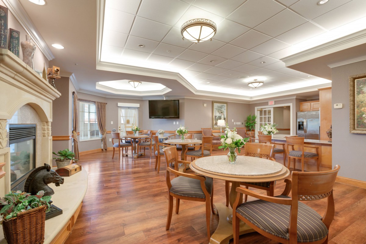 A well-lit dining area with wooden flooring and elegant furniture.