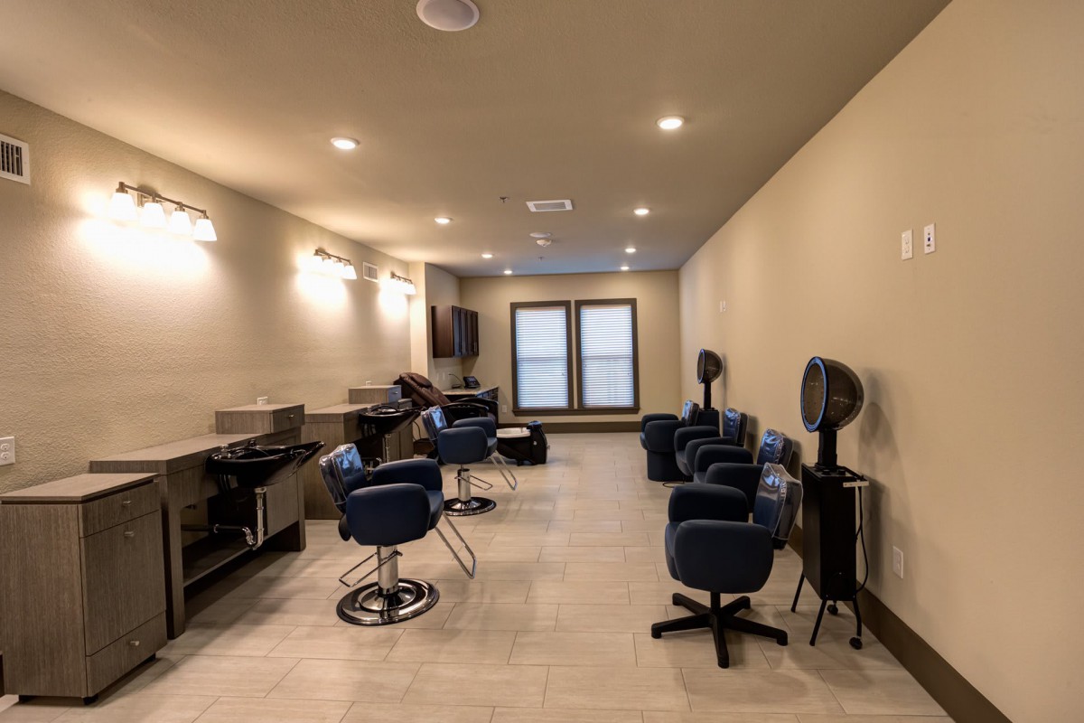 A modern hair salon interior with stylish chairs and well-lit mirrors.