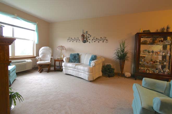 A cozy living room with a white sofa, blue cushions, and decorative elements.