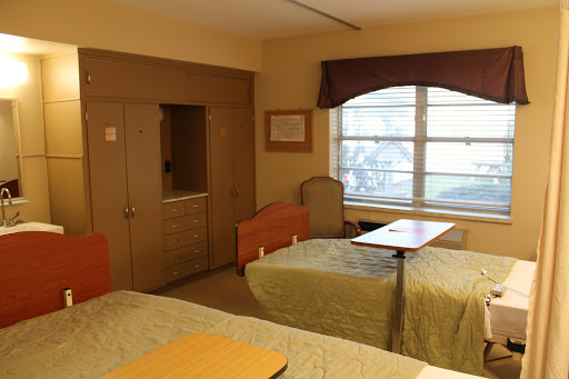 A simple and functional room featuring two beds, a window with natural light, and minimalistic decor.