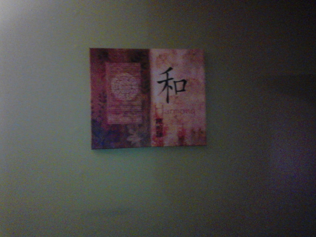 Abstract wall art featuring intricate designs and symbols on a green background.