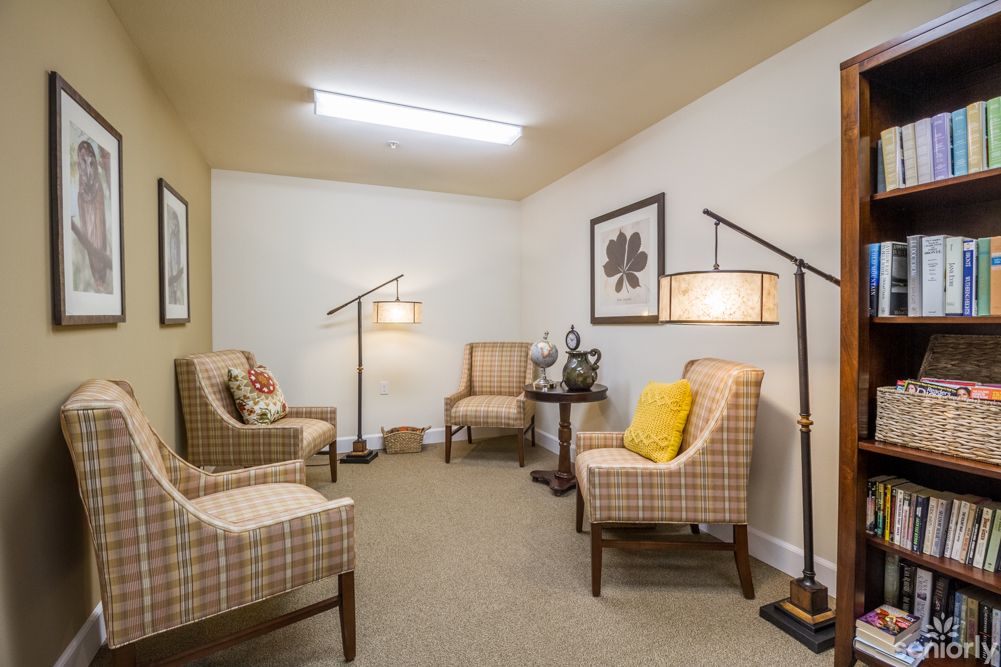 A cozy living room with plaid chairs and warm lighting.