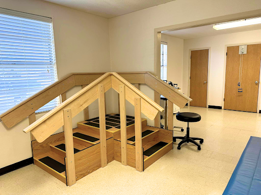 A rehabilitation facility featuring a wooden staircase structure designed for therapy sessions.
