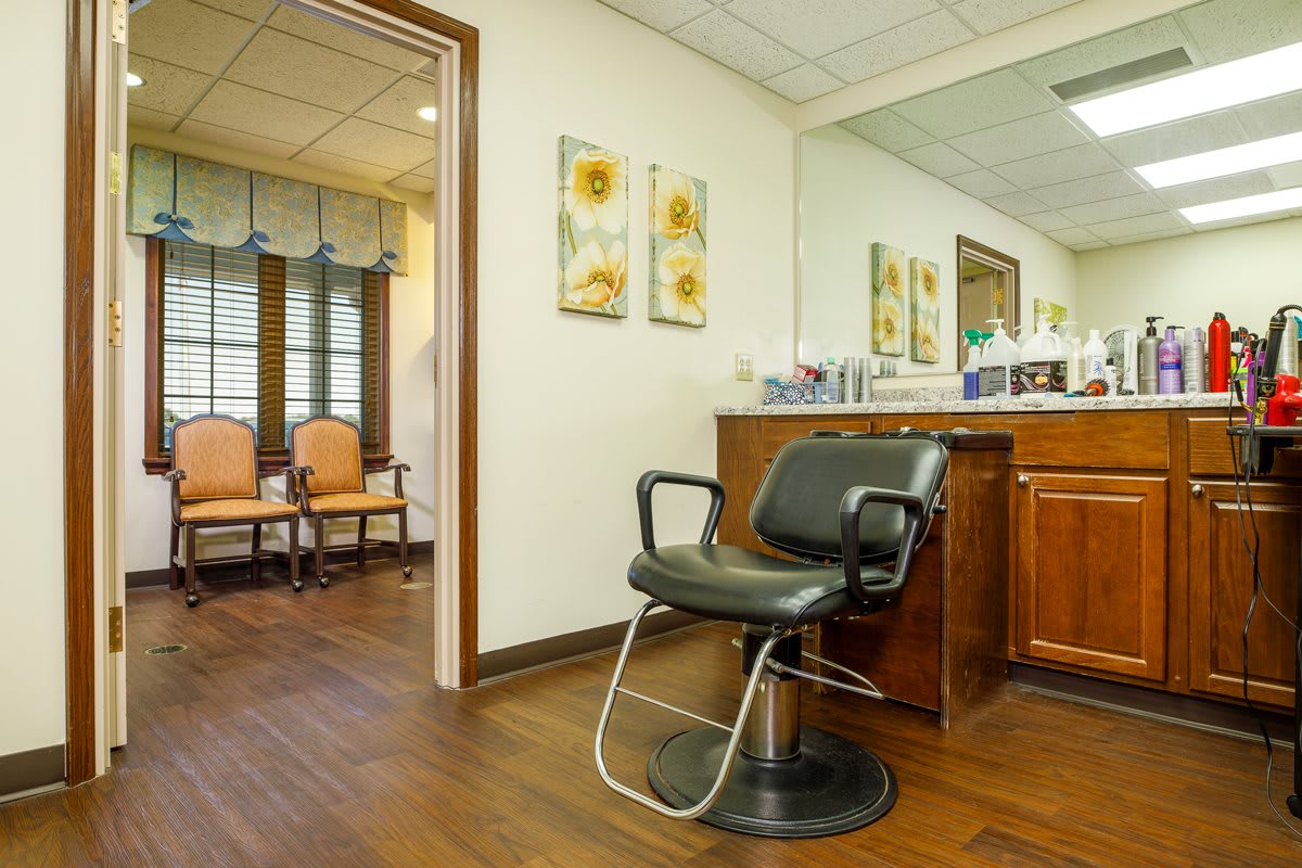 A cozy hair salon with a barber chair and a waiting area visible in the background.
