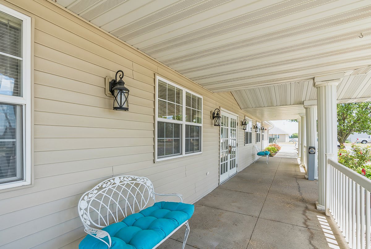 A welcoming porch with a cushioned bench and decorative lantern.