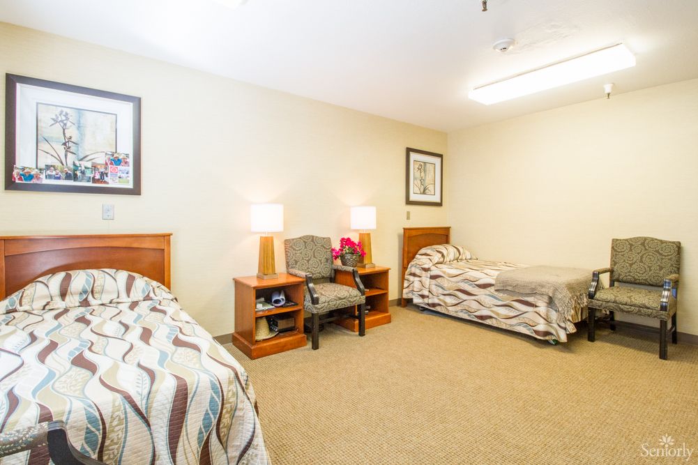 A cozy bedroom with twin beds, soft lighting, and simple decor.