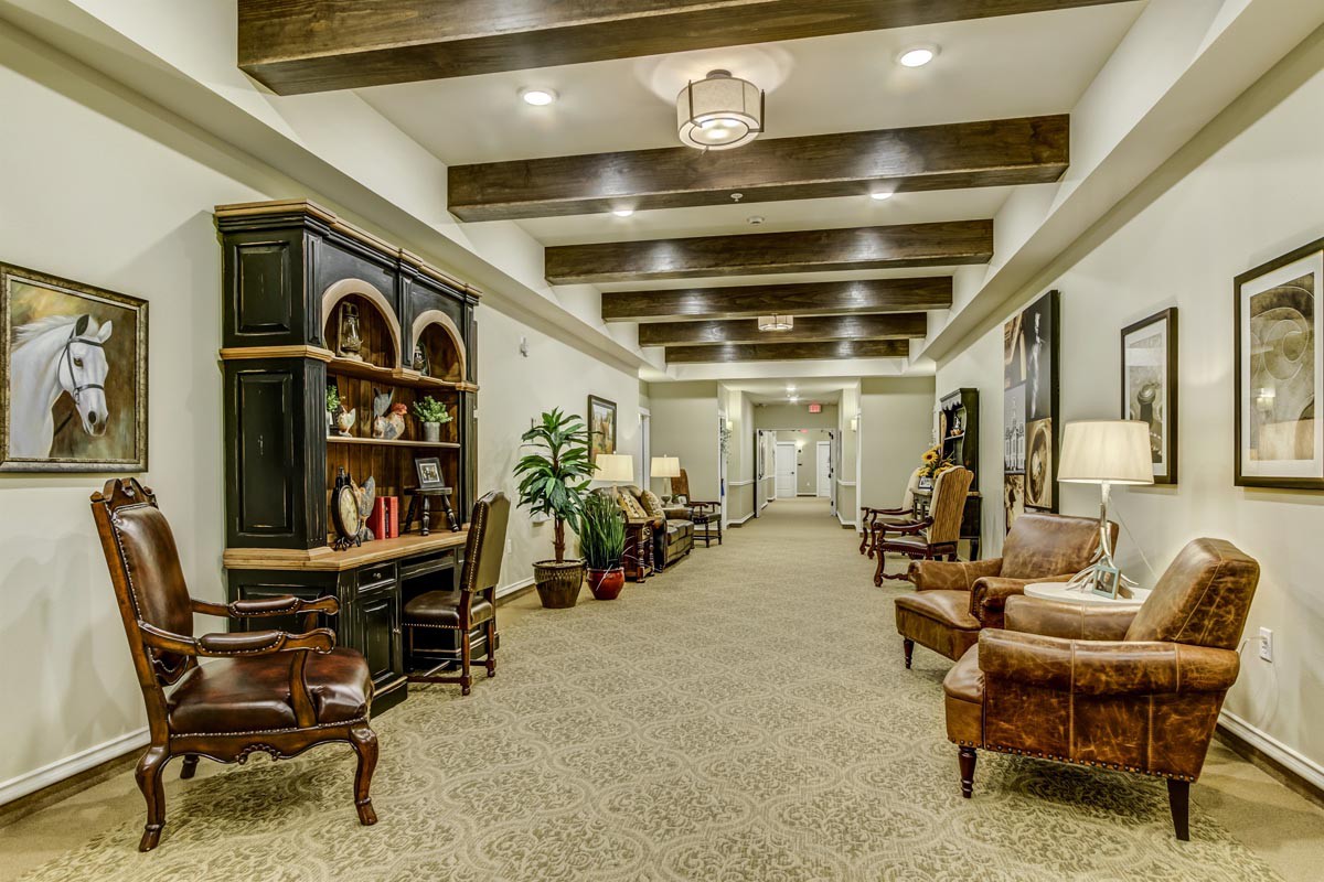 A well-decorated hallway with wooden ceiling beams and elegant furniture.