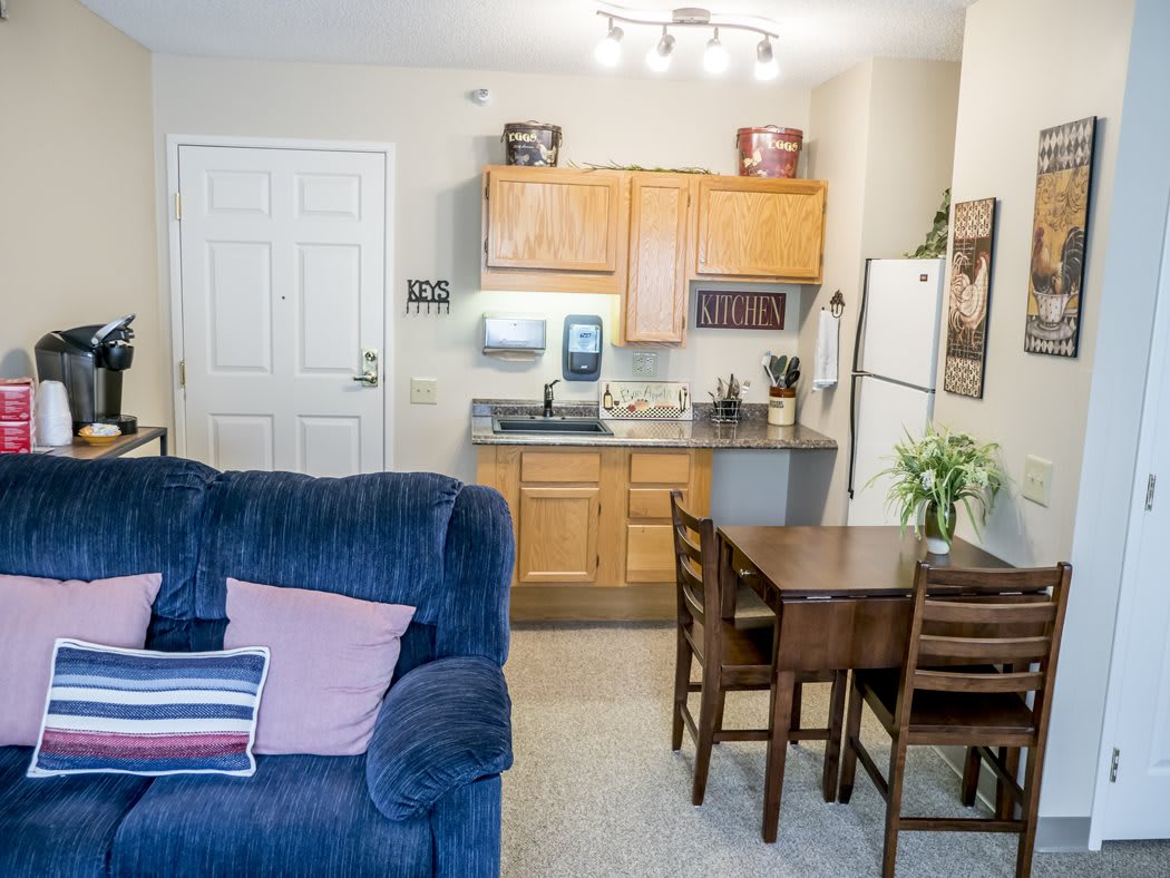 A cozy apartment with an open layout featuring a small kitchen and living area.