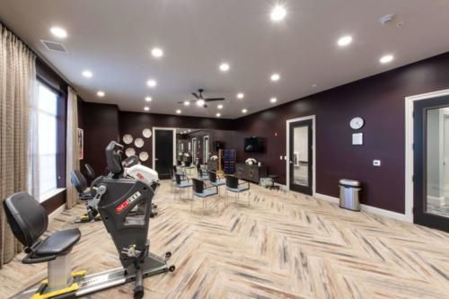 A modern gym with stationary bikes and exercise equipment in a well-lit fitness room.