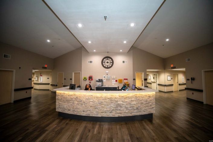 A spacious reception area with a curved desk and warm lighting.