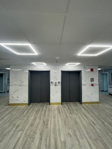 A modern elevator lobby featuring sleek designs and bright lighting.