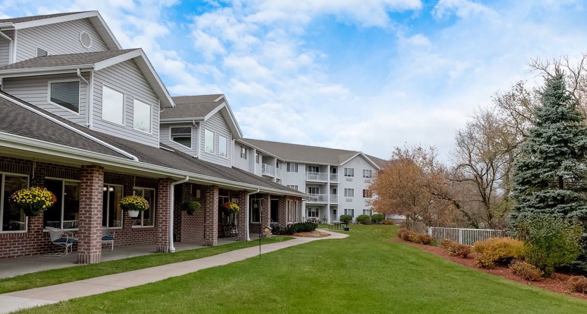 A view of a residential apartment complex with well-maintained lawns and landscaping.