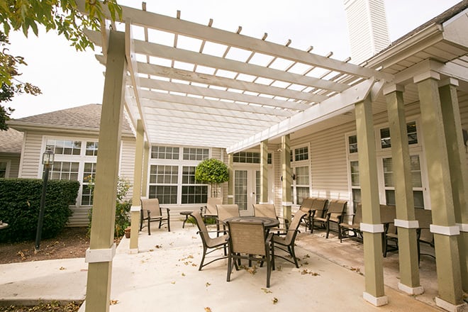 A cozy outdoor patio area with a pergola and seating arrangement.