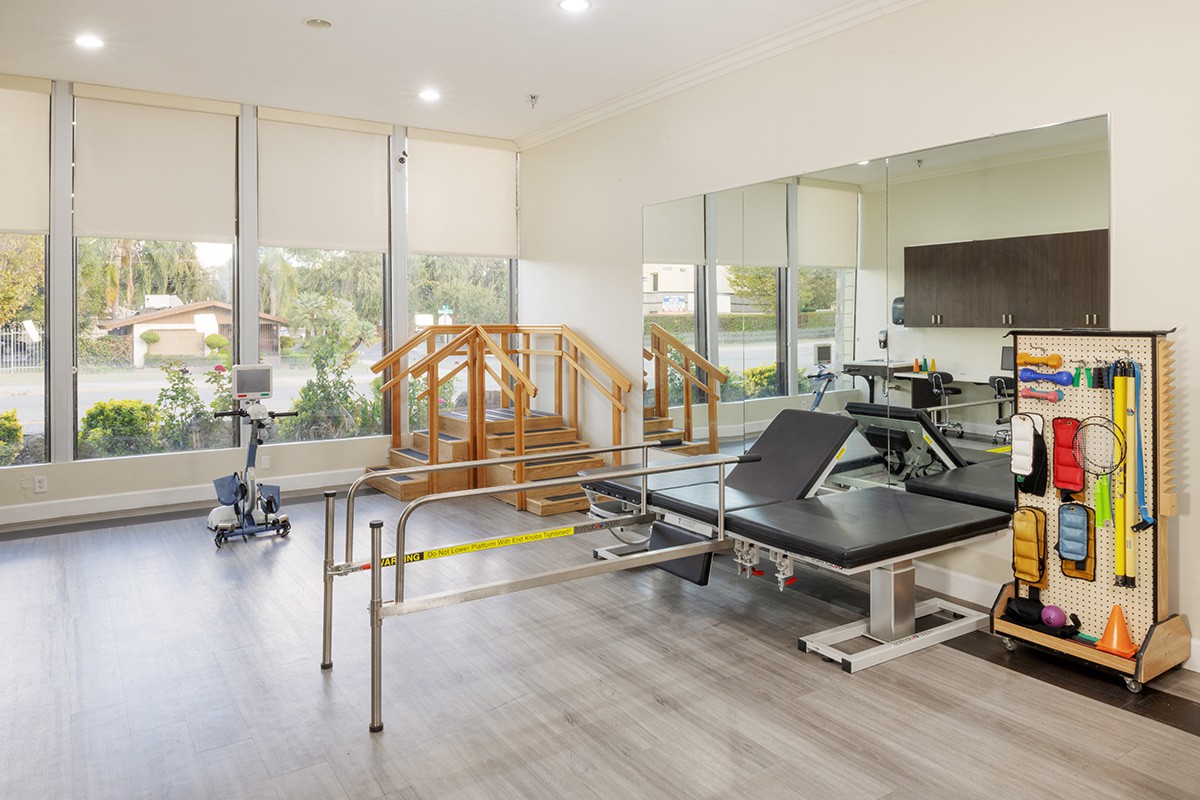 A well-equipped physical therapy room featuring various exercise and rehabilitation equipment.