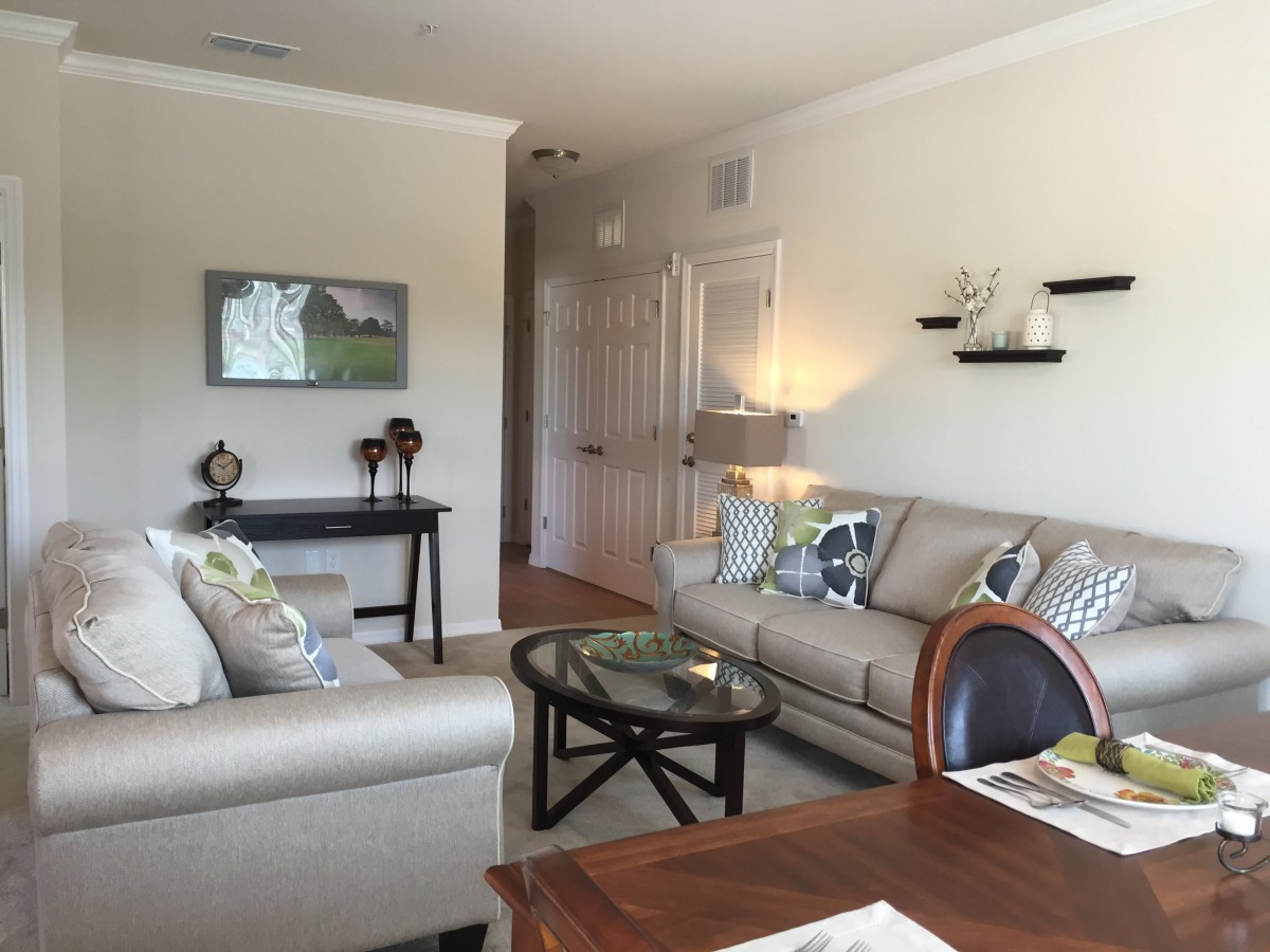 A modern living room featuring comfortable sofas, a glass coffee table, and stylish decor.