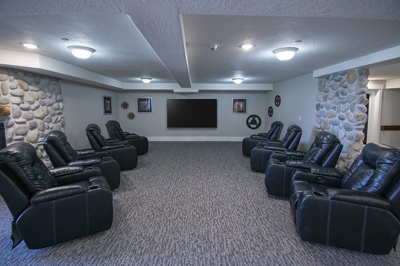 A spacious home theater with multiple recliners and a large screen.