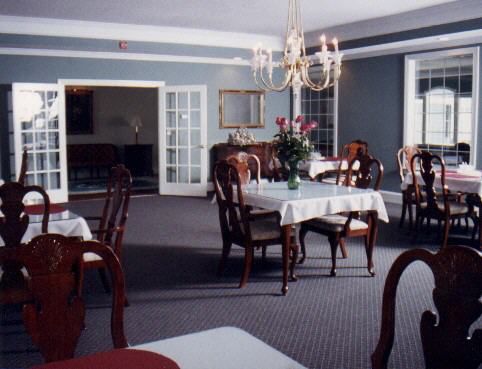 A sophisticated dining room with elegant furnishings and a chandelier.