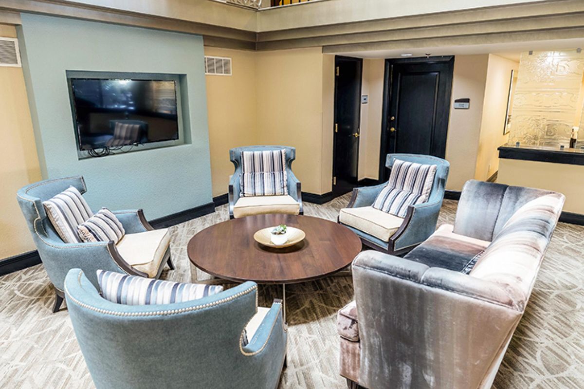 A cozy seating area featuring several striped armchairs arranged around a wooden coffee table.