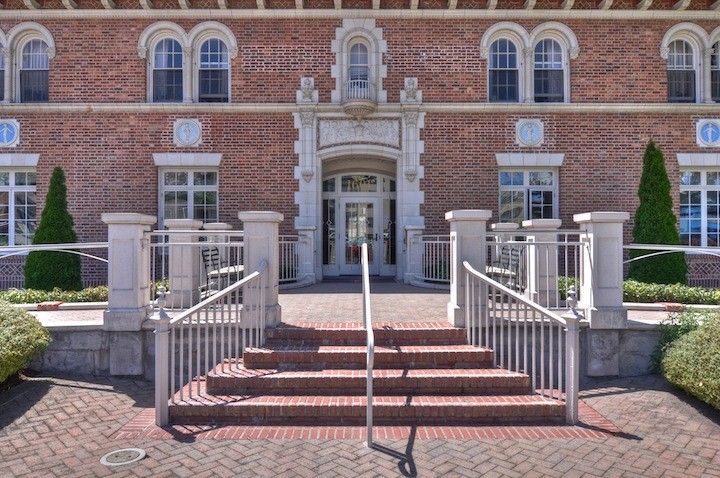 A historic brick building with an elegant entrance and stairs.