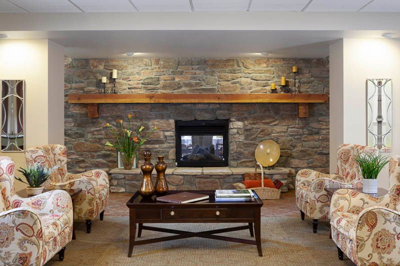 A cozy living room with a stone fireplace, elegant furniture, and tasteful decor.
