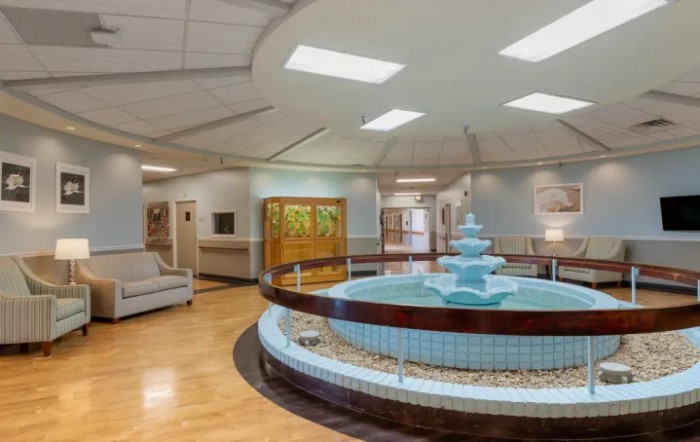 An elegant lobby interior featuring a central fountain and seating area.