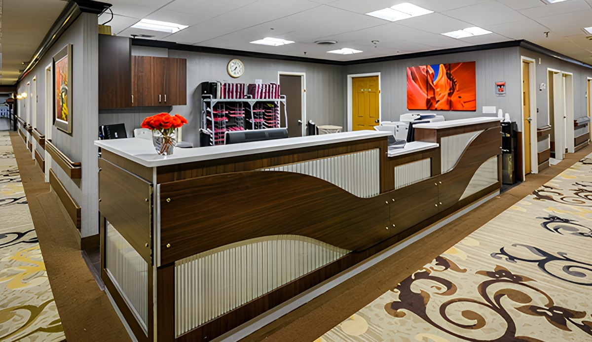A modern office reception area featuring a wooden desk, vibrant artwork, and decorative elements.