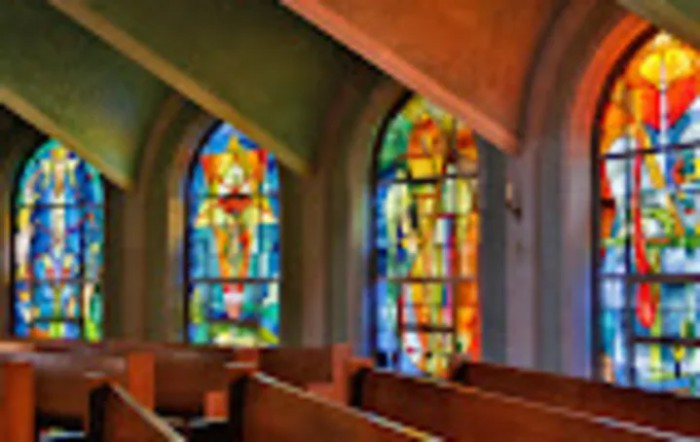 Interior view of a church with colorful stained glass windows.