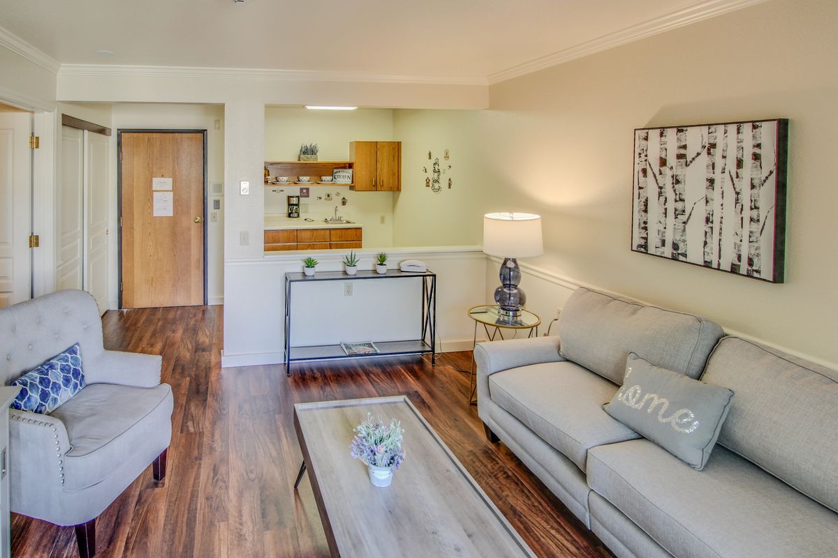 A cozy living room with modern furniture and an adjacent kitchen area.