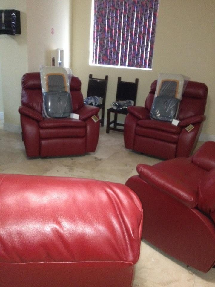 A cozy living room setup featuring multiple red recliner chairs.