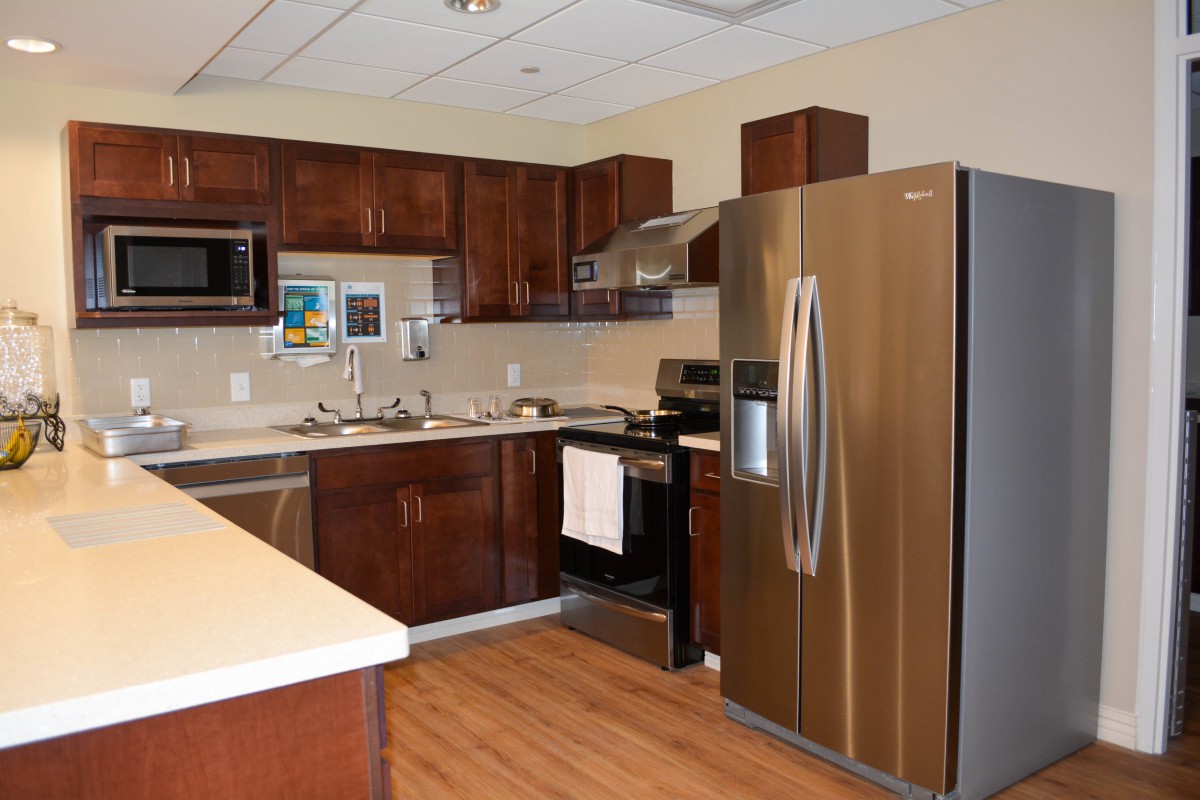 A modern kitchen featuring wooden cabinets, stainless steel appliances, and a sleek design.