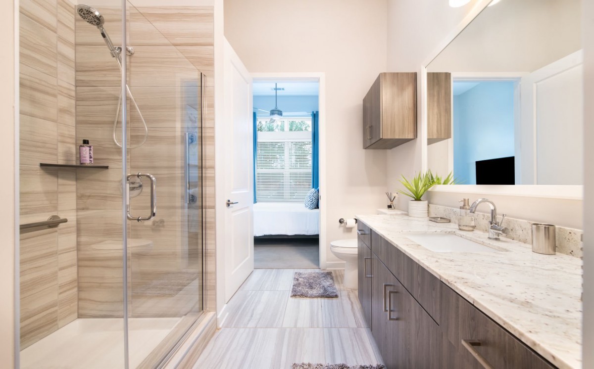 A modern bathroom with a large vanity, spacious shower, and stylish decor.