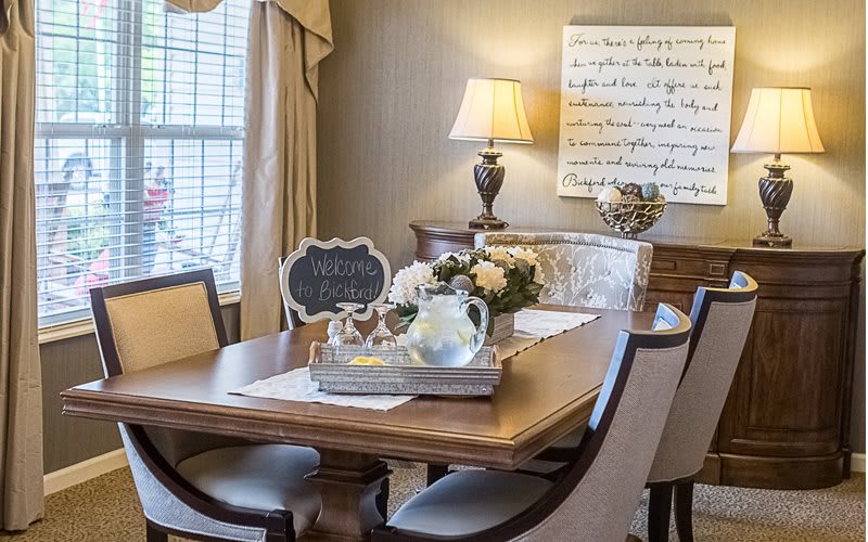 A cozy dining room with elegant decor and a wooden table set for gathering.