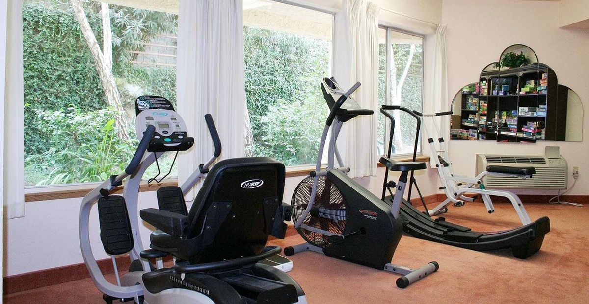 A well-lit gym with various exercise machines and equipment.