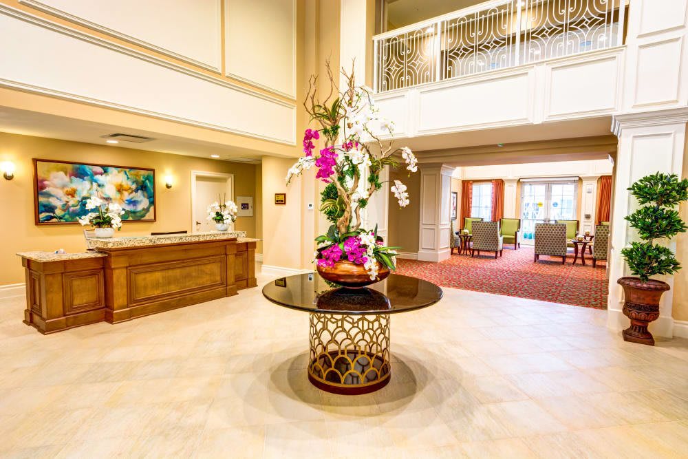 A beautifully decorated lobby with a flower arrangement on a central table.