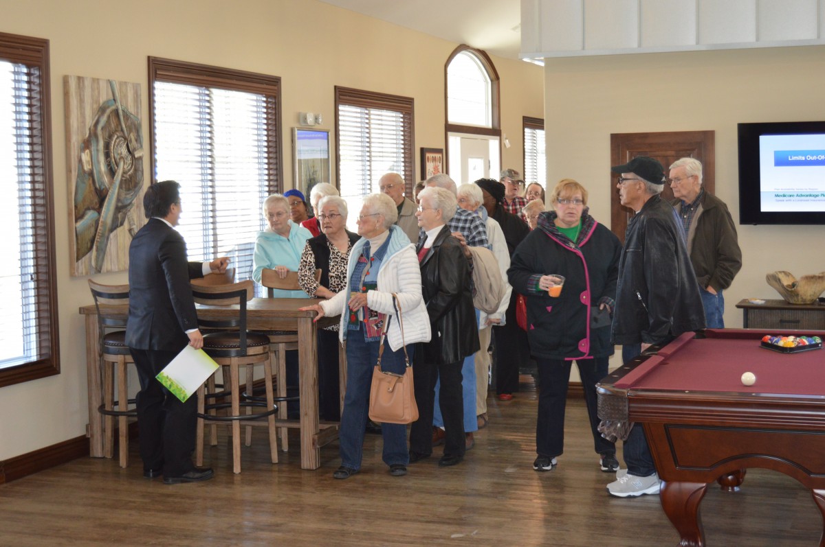 A group of seniors standing in line indoors, waiting for an event.