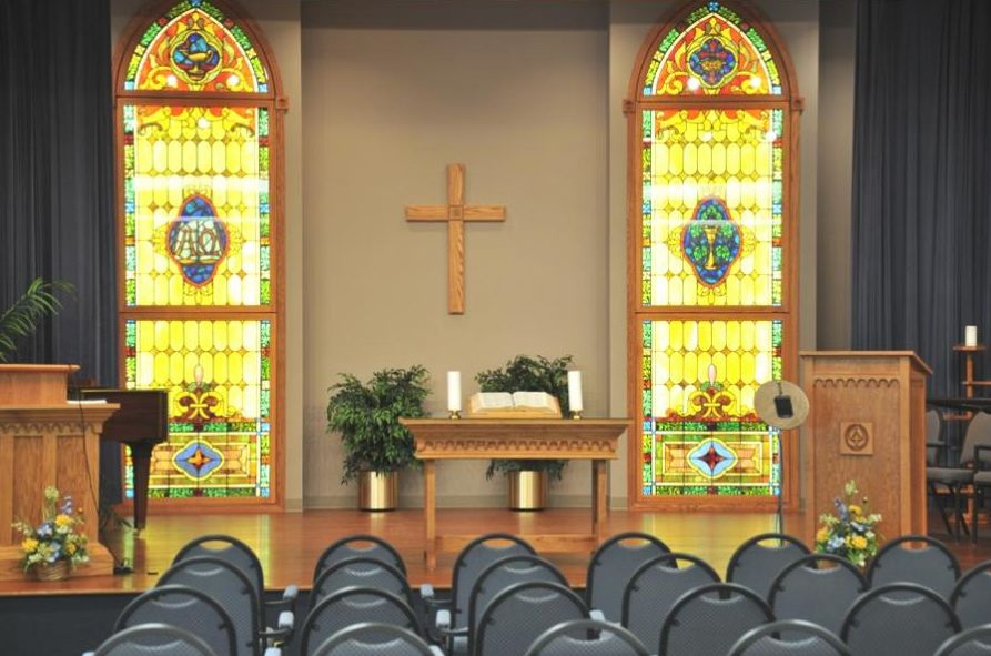 Interior of a church with stained glass windows and an altar.