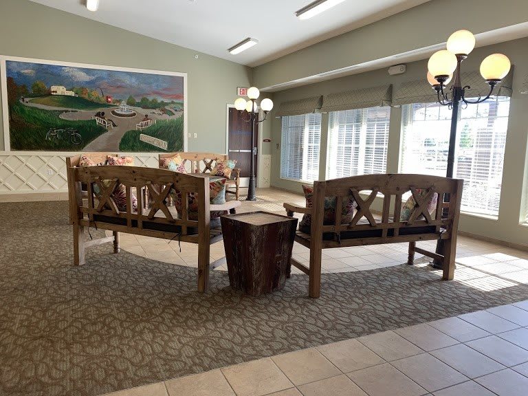 A cozy lobby area with wooden benches and soft lighting.