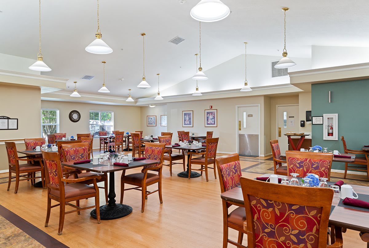 A spacious and well-lit dining area with neatly arranged tables and chairs.