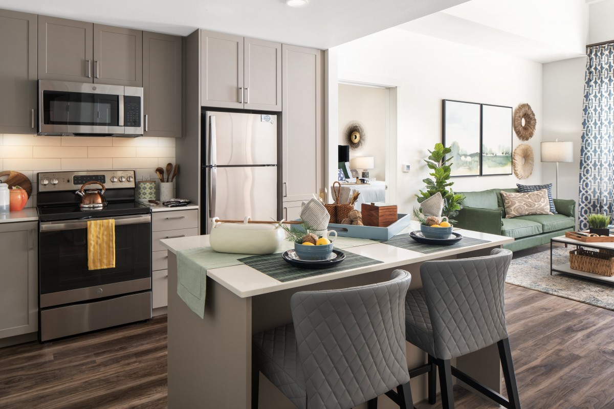 A modern kitchen with an island seating area, featuring sleek appliances and elegant decor.