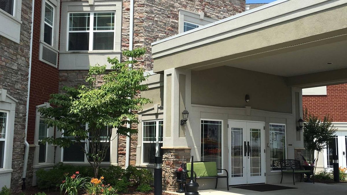 Front entrance of a modern residential building with a landscaped exterior.