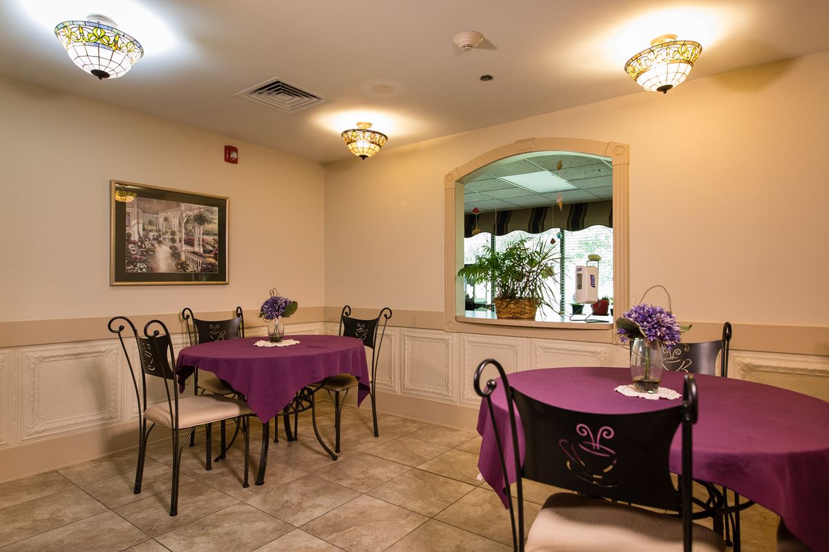 A cozy dining room with purple tablecloths and elegant decor.