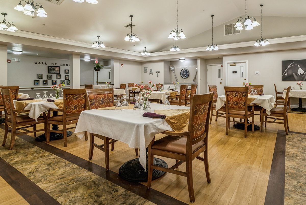 An elegant dining area with neatly arranged tables and chairs under warm lighting.