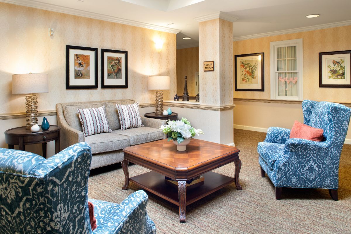 A cozy living room with a sofa, coffee table, and framed artwork on the walls.