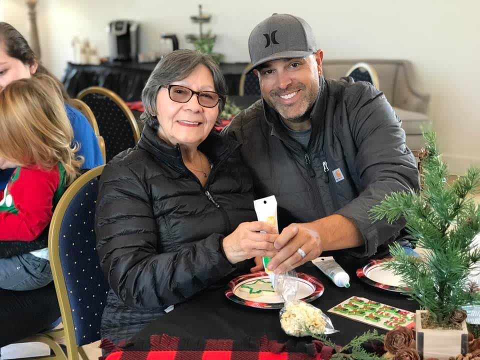 Two people smiling at a table, enjoying a festive gathering.
