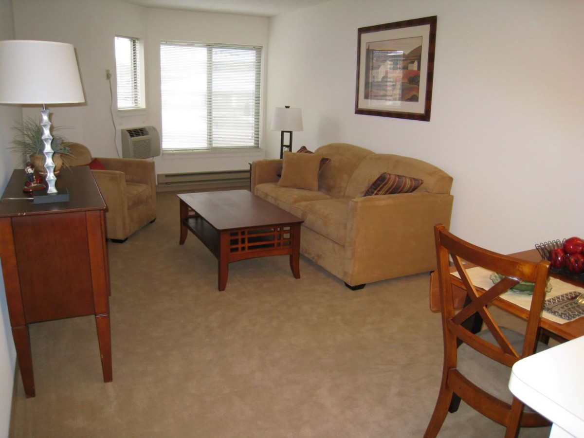 A cozy living room with a sofa, armchair, and coffee table.