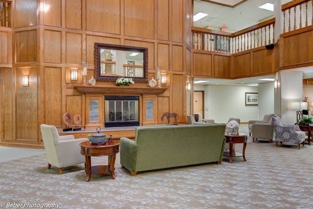 A modern lobby featuring comfortable furniture and elegant wood paneling.
