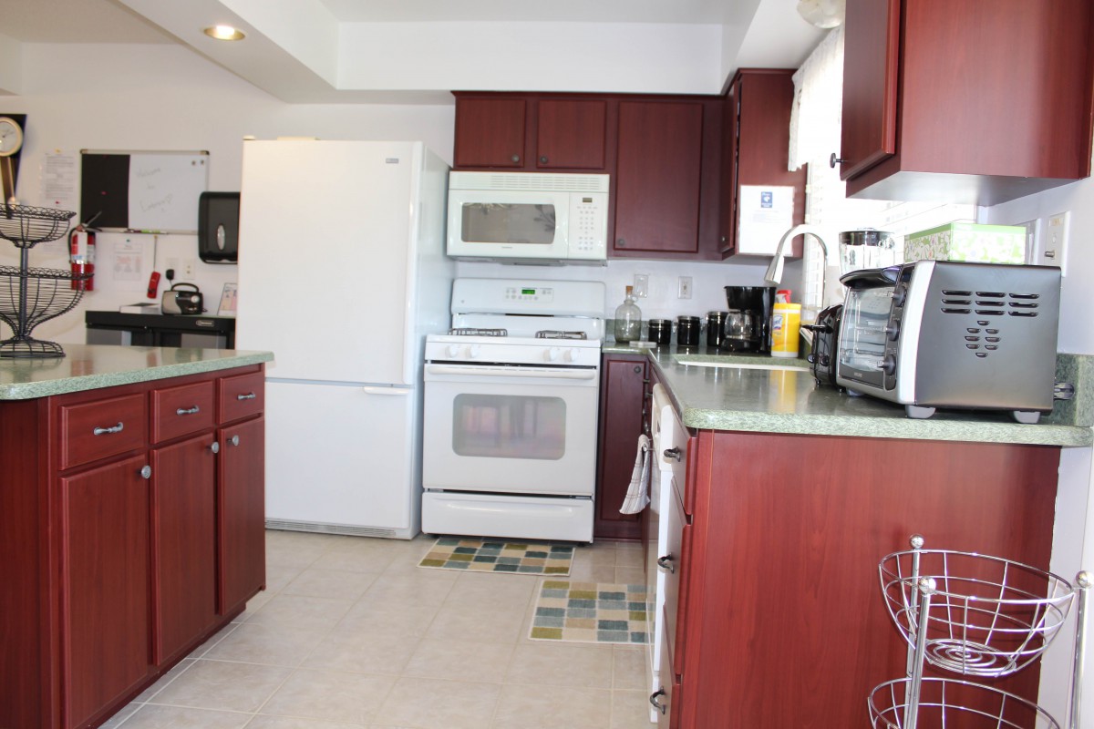 A modern kitchen with wooden cabinets and standard appliances.