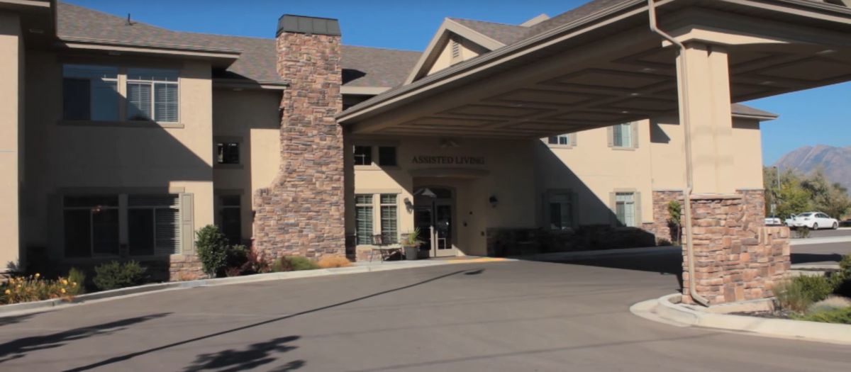 A building entrance with a covered driveway and stone chimney.