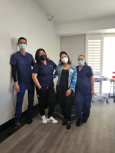 A group of healthcare professionals posing together in a clinic setting.