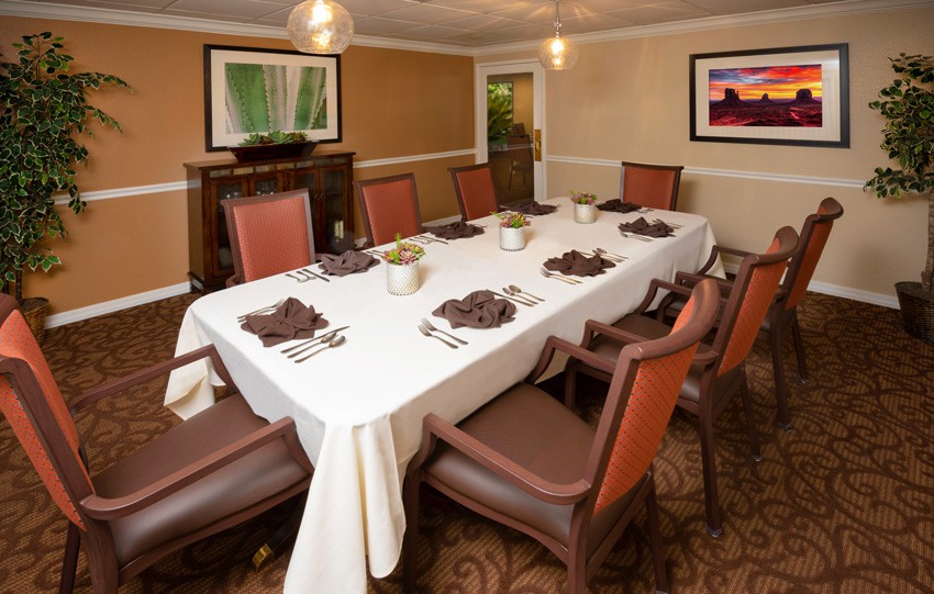 A formal dining room with a table set for eight people.